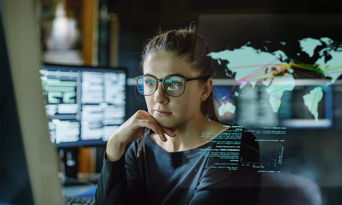 Female interpreting geographic data on multiple screens