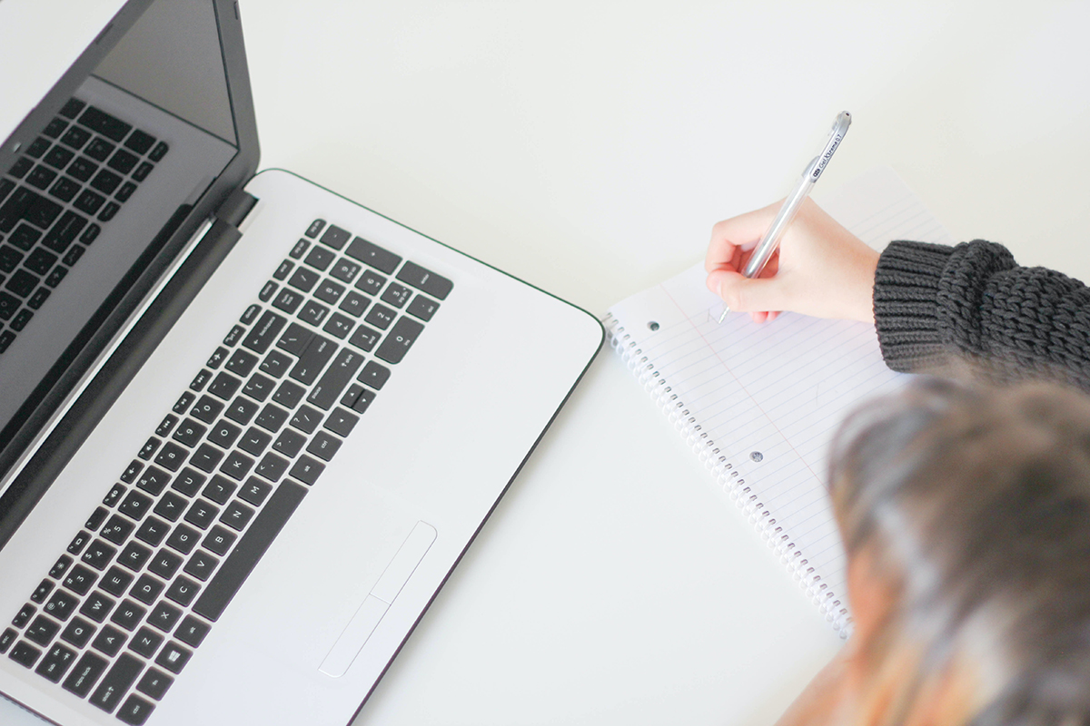 Person with a laptop and notebook